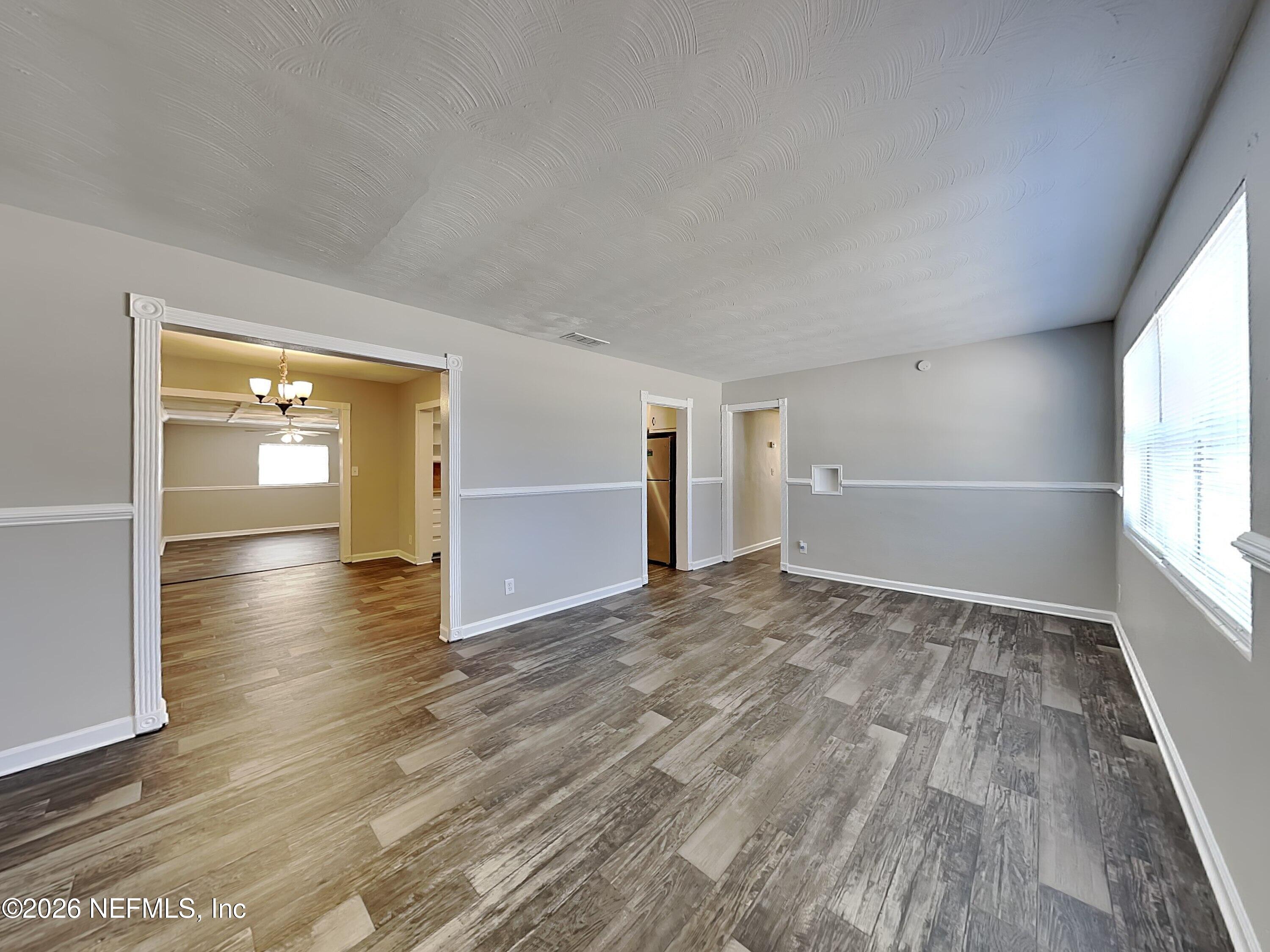 3403 Rogero Road Jacksonville, FL 32277 - Photo 4 of 19 wooden floor in an empty room with a window