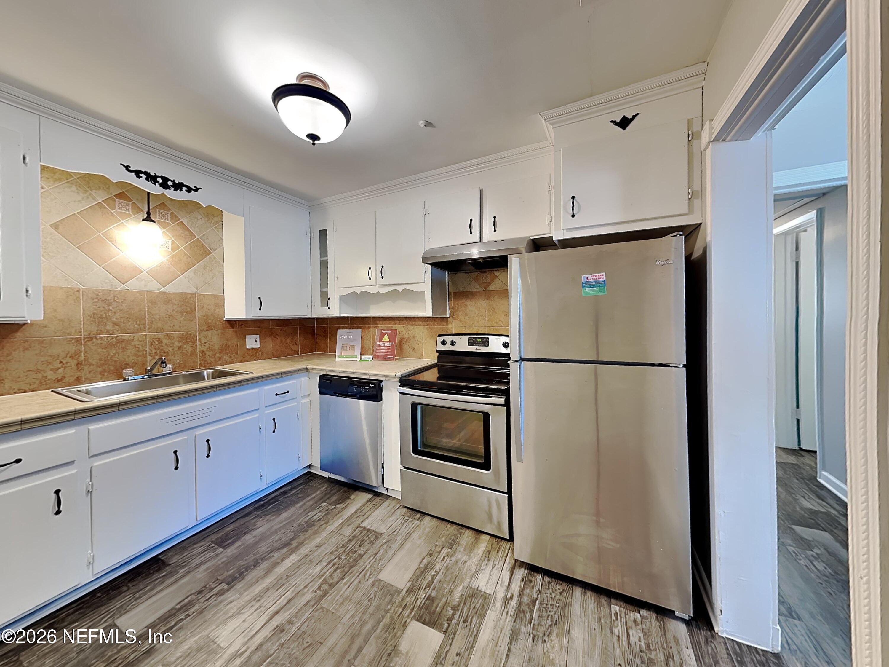 3403 Rogero Road Jacksonville, FL 32277 - Photo 8 of 19 a kitchen with stainless steel appliances granite countertop a refrigerator sink and cabinets