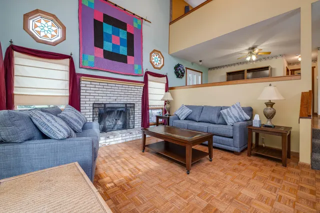 a kitchen with stainless steel appliances granite countertop a stove top oven a refrigerator a sink dishwasher and a dining table with wooden floor