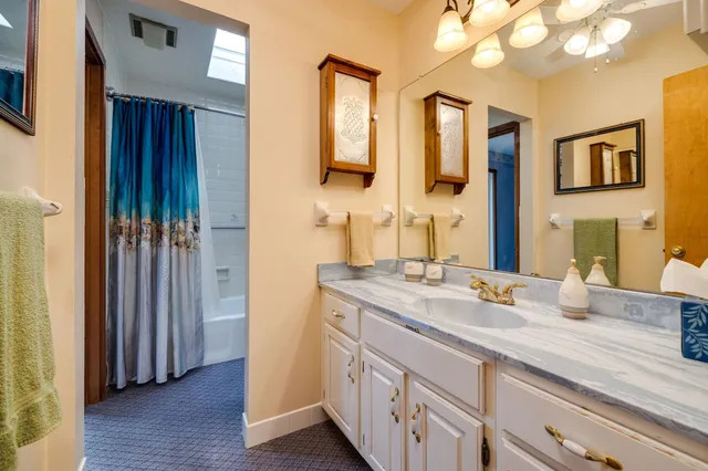 a view of an empty room with a window and a kitchen