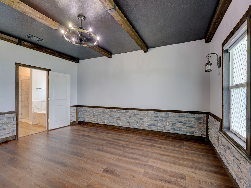 1716 Frontenac Street Leander, TX 78641 - Photo 18 of 34 a view of an empty room with wooden floor and chandelier