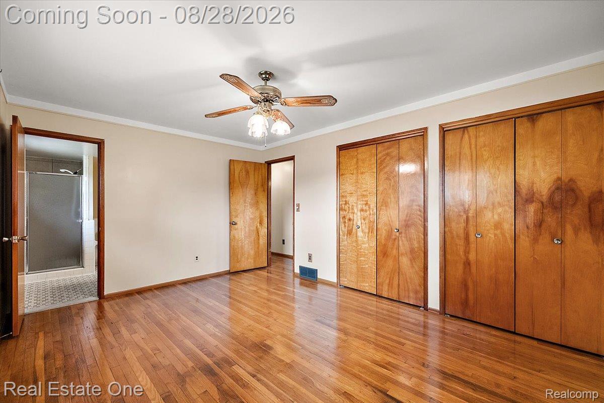 15250 34 Mile Road Armada, MI 48005 - Photo 41 of 49 Hardwood flooring, two wood-finish bi-fold closets, wood-finish doors, and a ceiling fan with integrated lighting