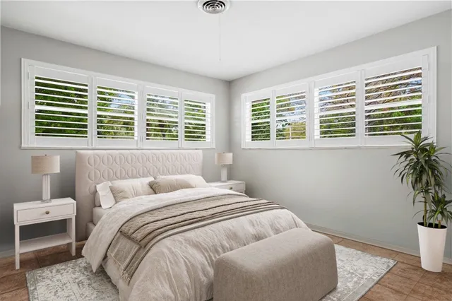 a bedroom with a bed and a potted plant