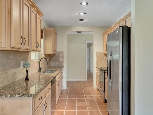 a kitchen with a sink refrigerator and cabinets