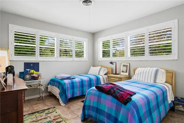 a bedroom with two beds and a large window