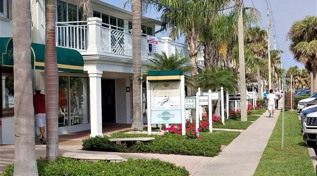 a front view of multi story residential apartment building with yard and green space