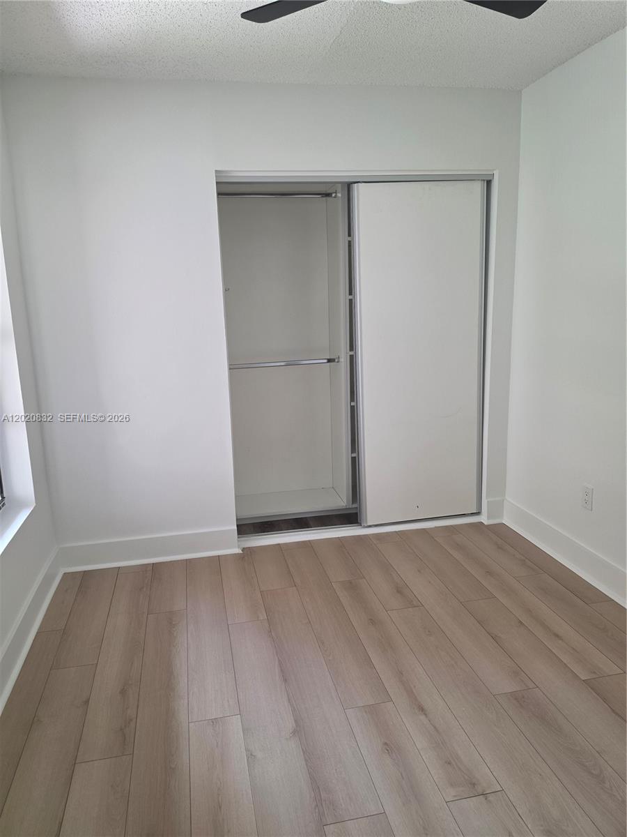 15240 Southwest 45th Terrace, Unit 54F Miami, FL 33185 - Photo 37 of 48 a view of an empty room with wooden floor and a window