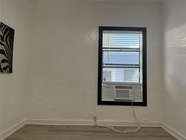 a view of a livingroom with wooden floor and a window