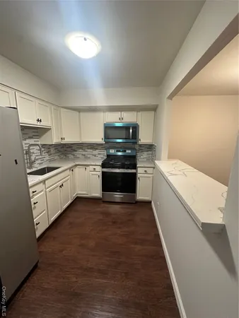 a kitchen with a stove sink and cabinets