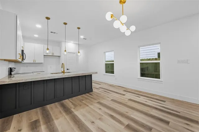a kitchen with a sink chandelier and view living room