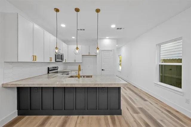 a kitchen with a sink a counter space and cabinets