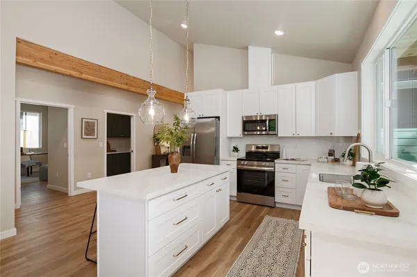 a kitchen with white cabinets and stainless steel appliances