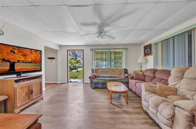 a living room with furniture a flat screen tv and a large window
