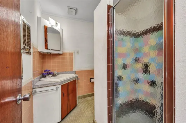 a bathroom with a granite countertop sink a mirror and shower