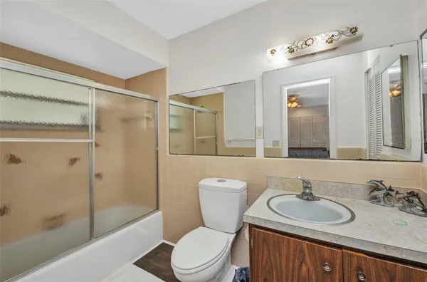a bathroom with a sink toilet vanity and shower