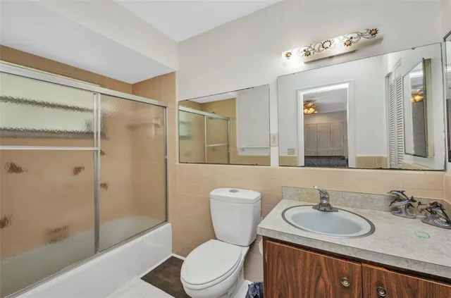 a bathroom with a sink toilet vanity and shower