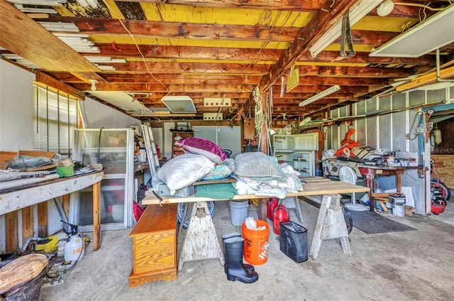 a utility room with stainless steel appliances lots of clutter