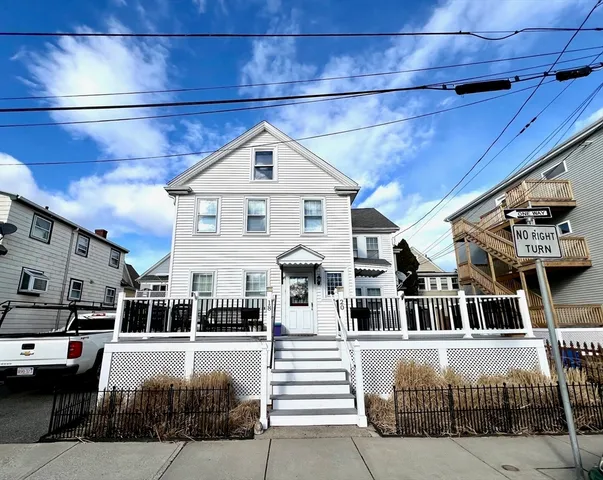 a front view of a building with streets and trees