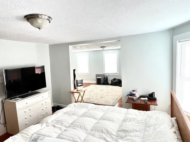 a bedroom with a large bed and a flat tv screen on dresser