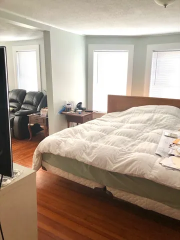 a bed sitting in a bedroom next to a window