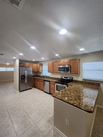a kitchen with stainless steel appliances a refrigerator and a stove top oven