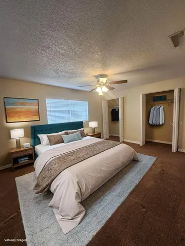 a spacious bedroom with a bed and a chandelier