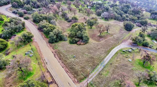 an aerial view of a house with a yard and mountain