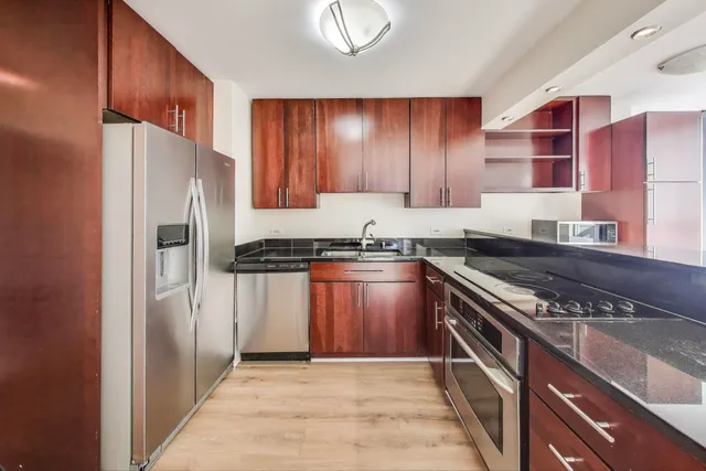 a kitchen with stainless steel appliances granite countertop a refrigerator and a stove