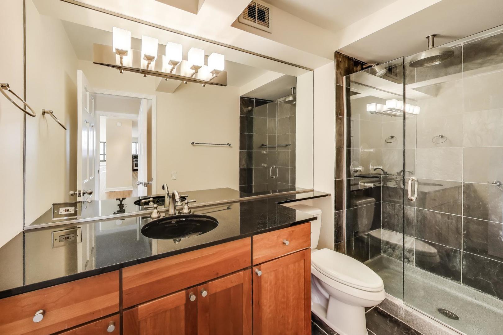1030 North State Street, Unit 5B Chicago, IL 60610 - Photo 21 of 36 a bathroom with a sink a toilet a mirror and shower