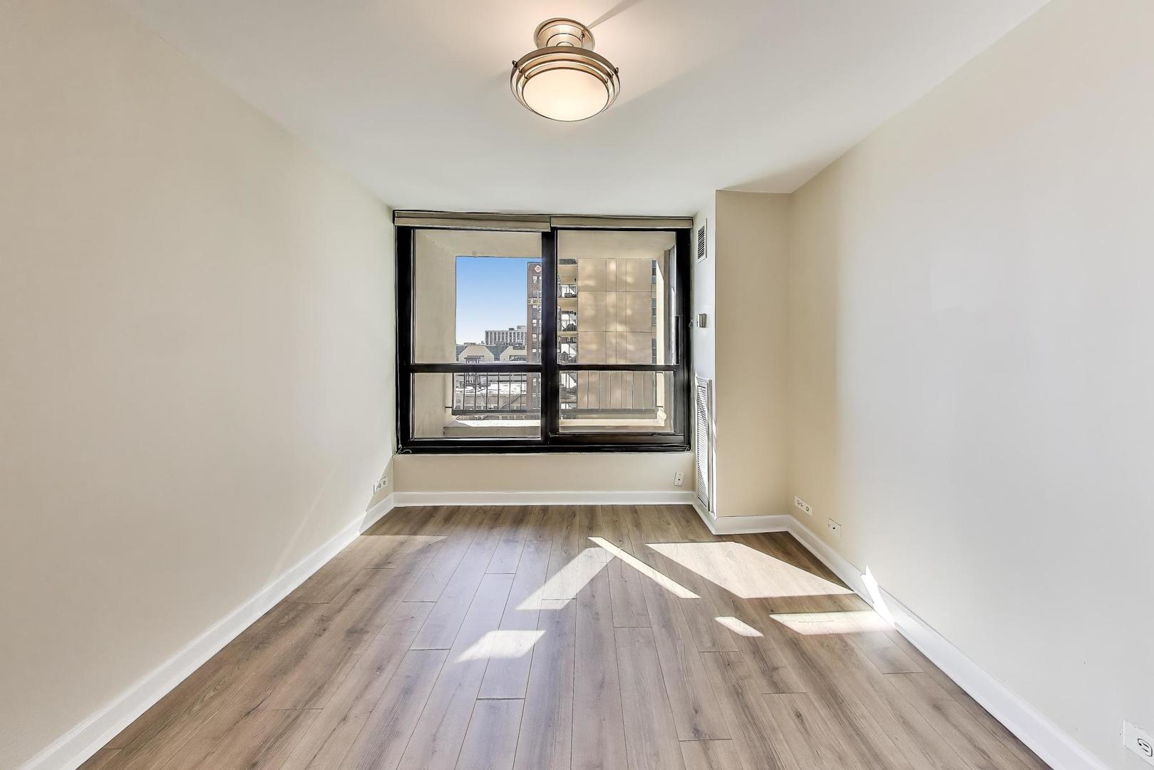 1030 North State Street, Unit 5B Chicago, IL 60610 - Photo 22 of 36 an empty room with wooden floor and windows