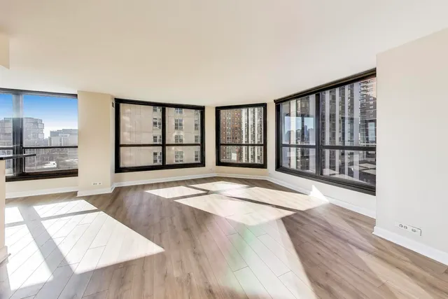 a view of a living room hardwood floor and a kitchen