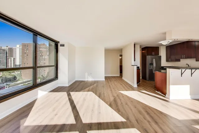 a view of a living room hardwood floor and a kitchen