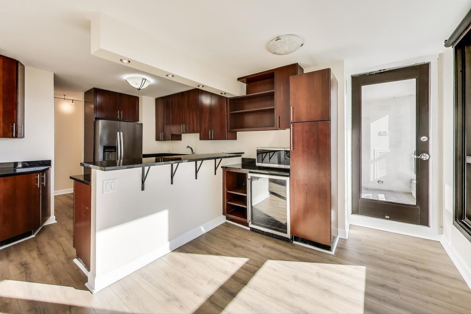 1030 North State Street, Unit 5B Chicago, IL 60610 - Photo 10 of 36 a view of kitchen with refrigerator stove and wooden cabinets