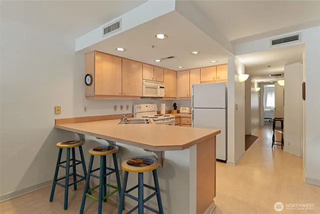 a kitchen with kitchen island a appliances dining table and chairs