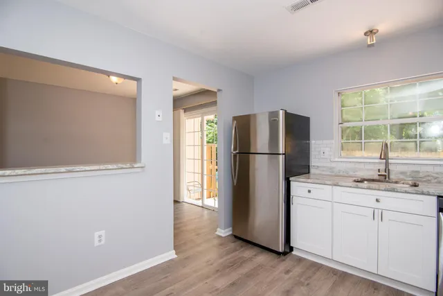 a kitchen with a refrigerator sink and cabinets