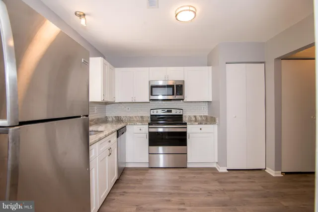 a kitchen with stainless steel appliances a refrigerator sink and microwave