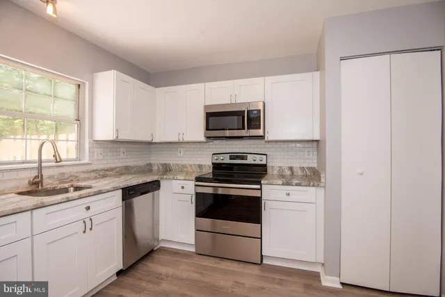 a kitchen with a sink stove and microwave