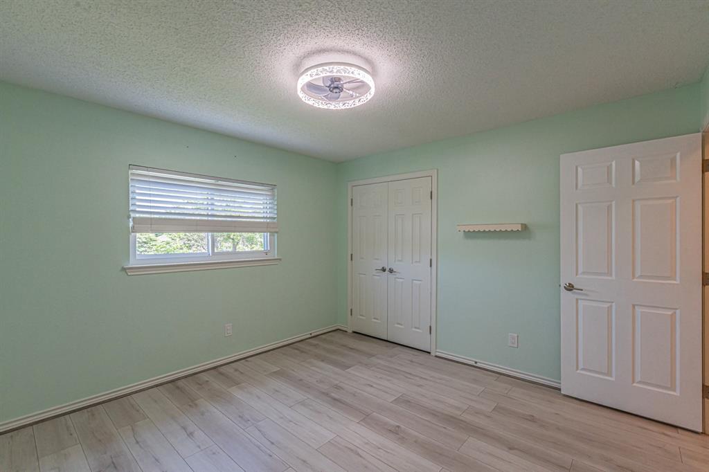300 Sundance Circle Irving, TX 75063 - Photo 28 of 39 Bright room featuring wood-finish flooring, a double-panel window with blinds, and white bi-fold closet doors