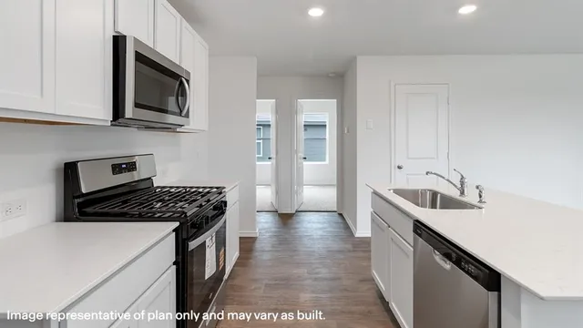 a kitchen with stainless steel appliances granite countertop a sink and a stove