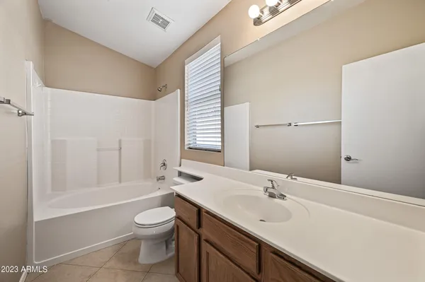 a bathroom with a toilet a sink a mirror and a bathtub