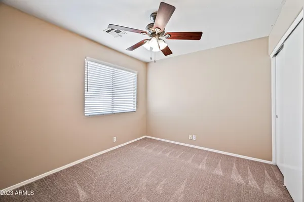 an empty room with a window and a fan