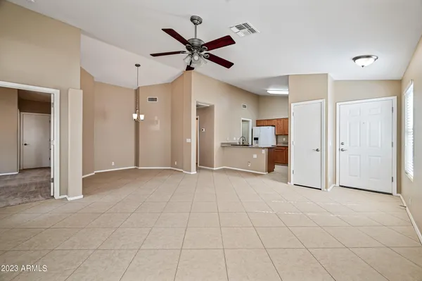 a view of a livingroom with a chandelier fan and refrigerator