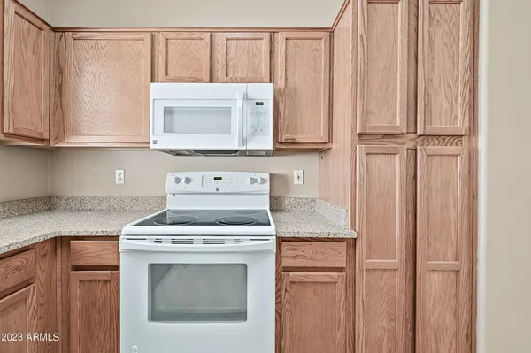 a kitchen with granite countertop white cabinets and white appliances