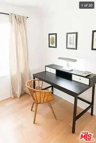 a living room with a table and paintings on the wall