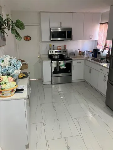 a kitchen with stainless steel appliances granite countertop a sink and dishwasher a stove top oven with wooden floor