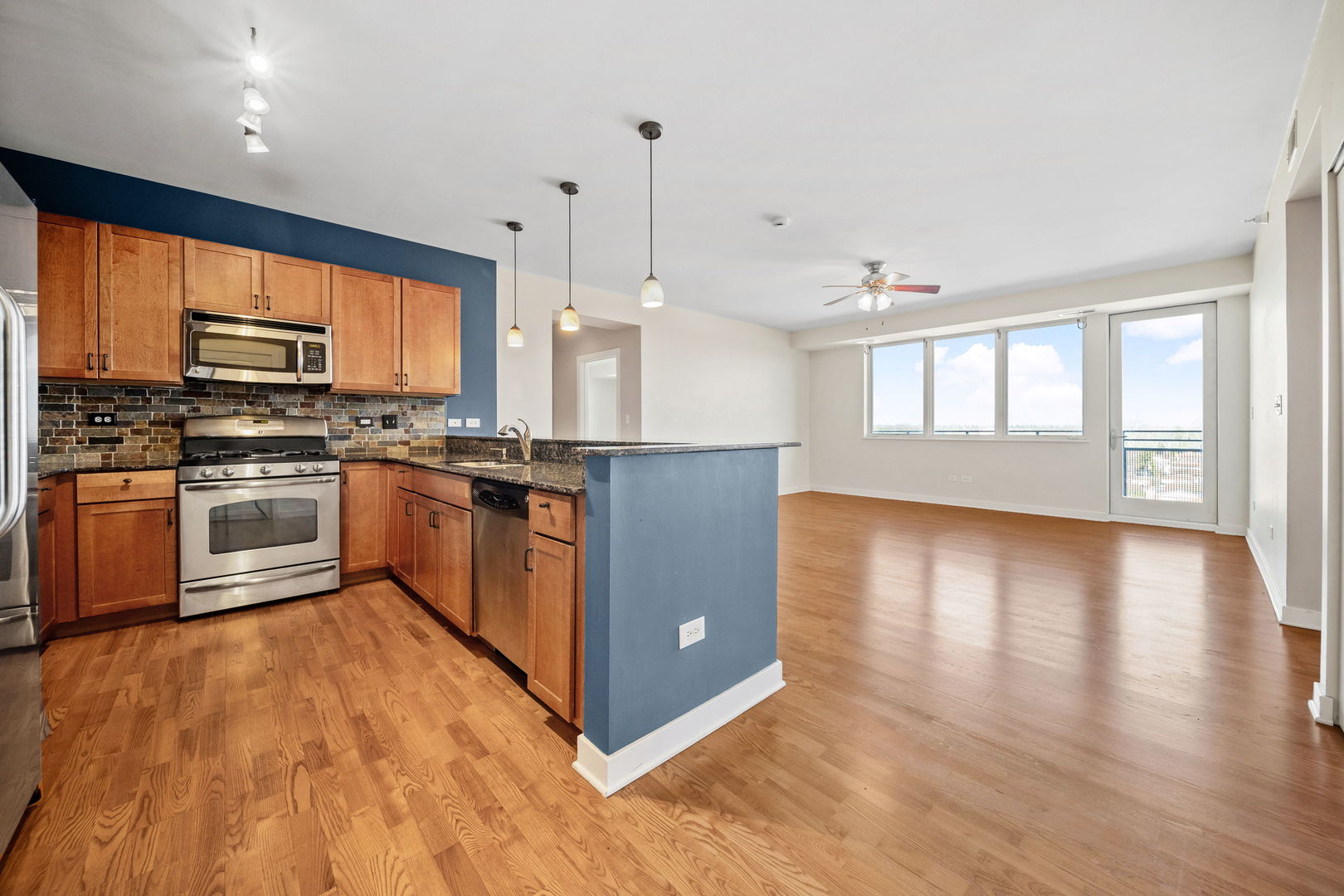 1905 South Wolf Road, Unit 605 Hillside, IL 60162 - Photo 10 of 31 a kitchen with stainless steel appliances granite countertop a stove top oven a sink dishwasher a refrigerator and a dining table with wooden floor