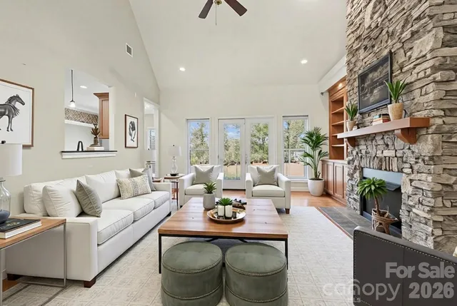 a living room with furniture a fireplace and a large window