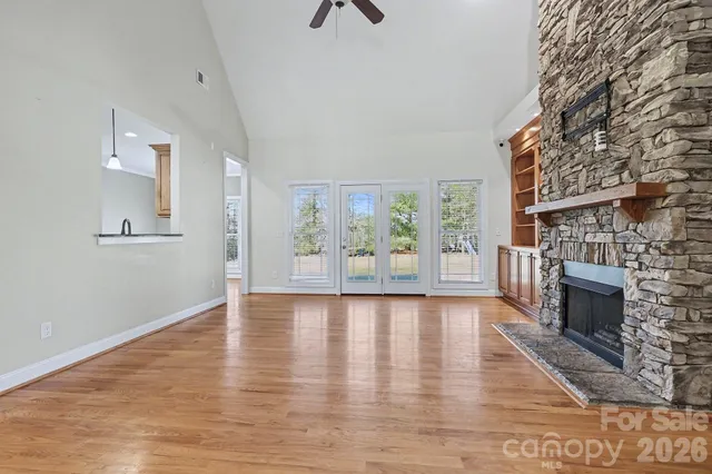 a view of an empty room with a fireplace and wooden floor