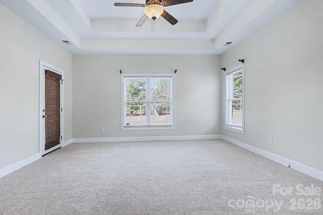 an empty room with ceiling fan and window