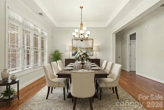 a dining room with furniture a large window and wooden floor